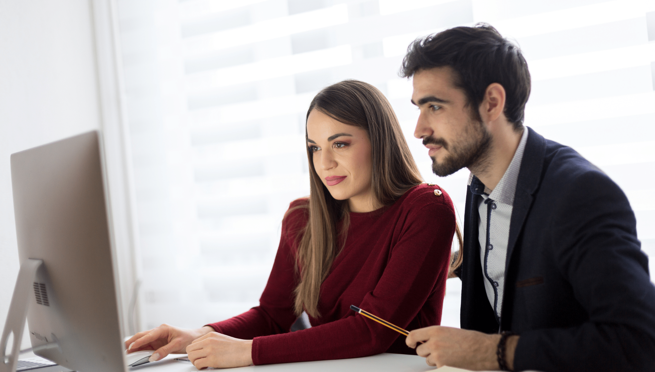 Man and woman looking at computer screen at work.